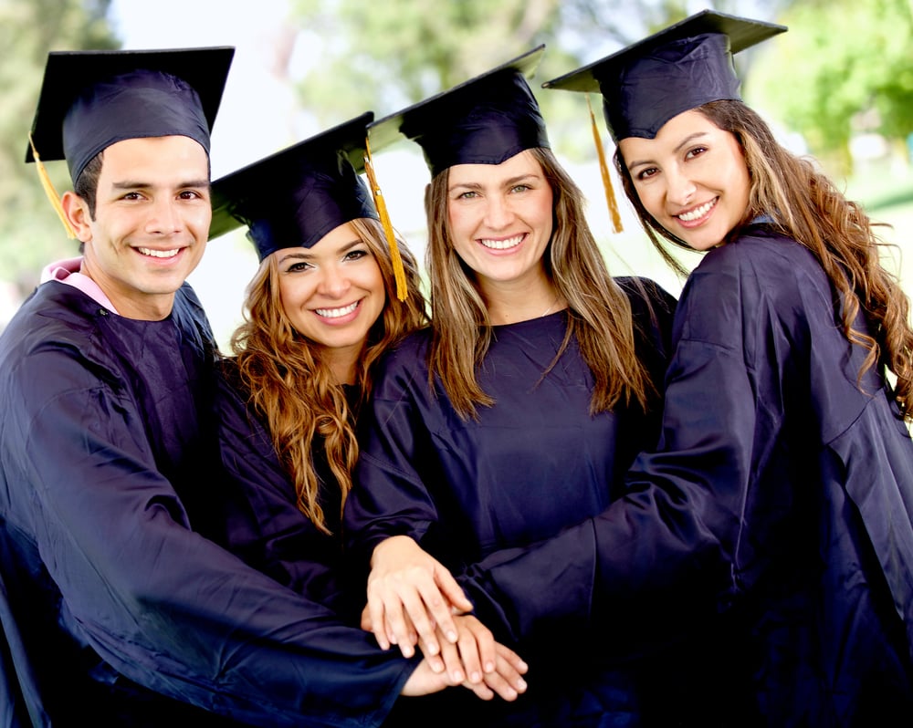 Group of students in their graduation with hands together - teamwork concepts