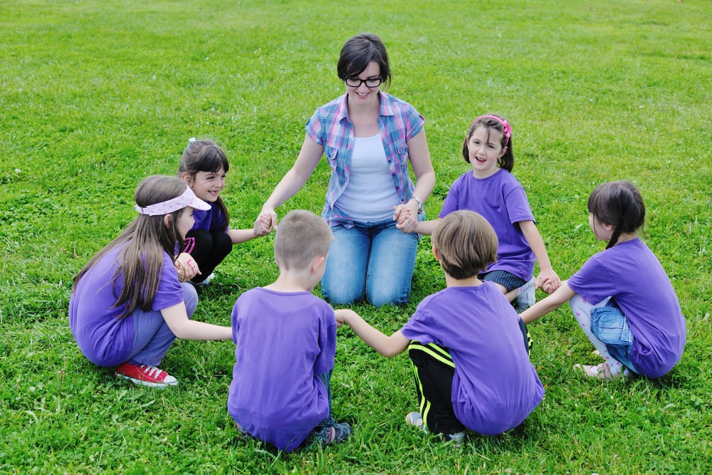 happy preschool kids group have fun and play game on outdoor classes in nature